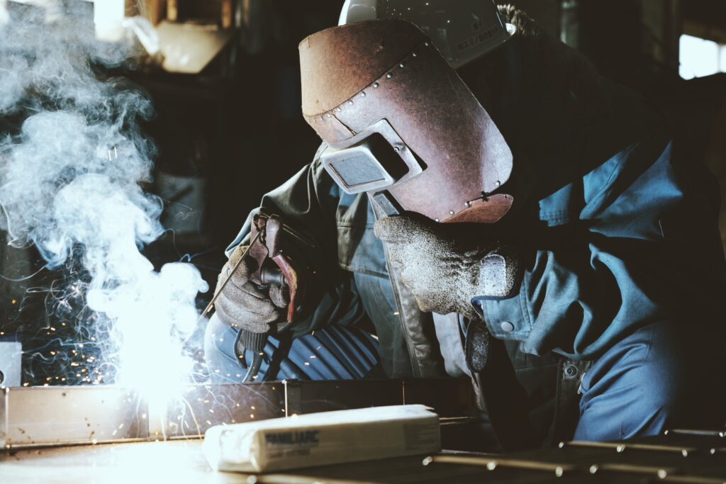 曲げ終わったものをアーク溶接する職人