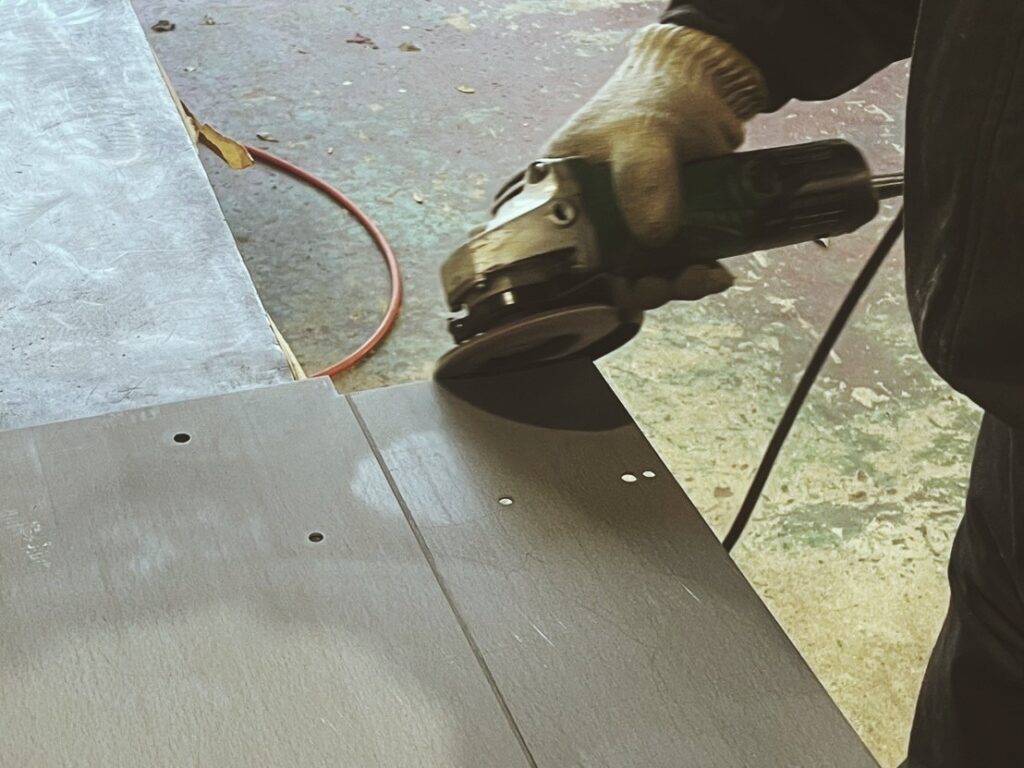 バリをやすりや機械で取り除き、表面をなめらかにする作業